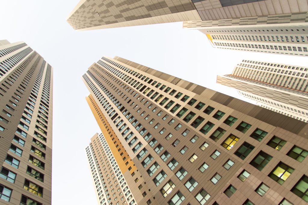 Upward view of modern skyscrapers under clear sky showcasing urban architecture.